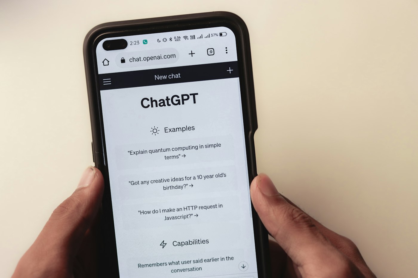 A person holding a phone showing an AI chatbot